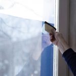 A hand tinting windows for improved comfort and privacy in the workspace.